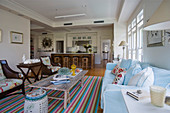 Brightly striped rug in living room with open-plan kitchen in background