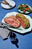 Roast beef with a herb crust and bacon beans