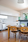 Dining area in open-plan kitchen with white cupboards