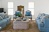 Blue sofas and chairs around coffee table in living room