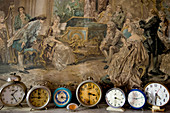 Collection of alarm clocks in front of painting