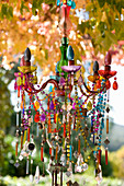 Chandelier with brightly coloured beads in garden