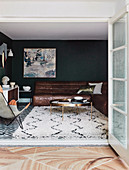 Coffeetable und Ledercouch im Wohnzimmer mit dunkelgrüner Wand