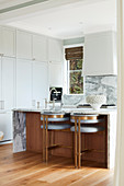 White, floor-to-ceiling fixtures and breakfast bar in open kitchen