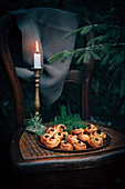Safran-Zimt-Gebäck mit Weihnachtsdeko und Kerze auf Stuhl