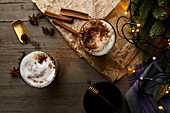 Chai latte in glasses with milk foam, cinnamon and anise stars