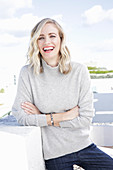 A blonde woman wearing a light-grey jumper