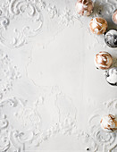 Marmorierte Christbaumkugeln auf weißem Untergrund mit Ornamentverzierungen