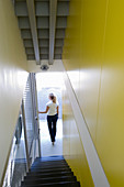 Schmaler Treppenabgang mit gelber Seitenwand in modernem Architektenhaus