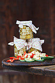 Preserved cream cheese in jars and on cucumber, tomatoes and peppers