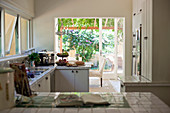 White-tiled worksurface in country-house kitchen with terrace access