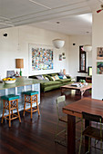 Sofa, stools and breakfast bar and dining table in vintage-style, open-plan interior