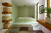 Minimalistisches Badezimmer mit stufenförmiger Anordung von Dusche und Badewanne