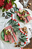 A table laid for Christmas decorated with a leaf pompom garland