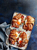 Englische Frühstücks-Croissants mit Bacon, Baked Beans und Spiegelei