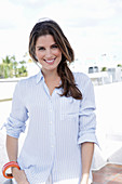 A young woman wearing a light, striped shirt