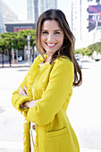 A young woman wearing a yellow bouclé jacket
