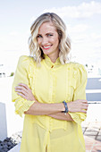 A blonde woman wearing a frilly yellow blouse