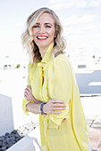 A blonde woman wearing a frilly yellow blouse