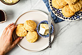 Selbstgebackene Süßkartoffel-Scones mit Butter auf Teller