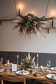Gedeckter Hochzeitstisch, darüber Gesteck aus Trockenblumen im Raum mit Industrie-Flair