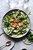 Green Salad with halloumi and dressing in a ceramic bowl
