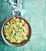 Frying pan potato bread with melting raclette and pickle dressing