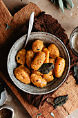 A bowl full of homemade pumpkin gnocchi with butter and sage
