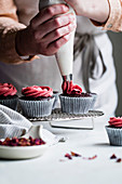Making chocolate cupcakes with pink frosting