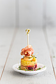Small potato tortilla with cress, raw ham and a skewer
