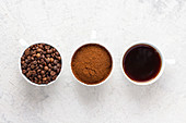 Coffee cups with coffee beans, ground coffee and filter coffee