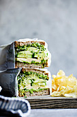 Käse-Sandwich mit Avocadocreme, Gurke, Zucchini und Sprossen