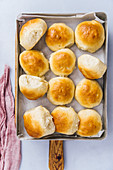 Homemade yeast dinner rolls topped with melted butter in a baking pan