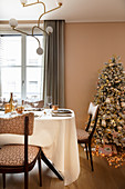 Christmas tree and festively set table in pink dining room