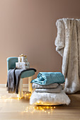 Gifts on upholstered stool and stack of cushions and blankets