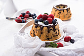 Small vegan stracciatella sponge cakes with soy cream and berries