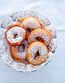 Donuts with powdered sugar in a silver bowl