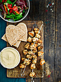 Griechische Hühnerspiesse mit Salat, Hummus und Pitas