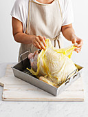 Whole roast turkey preparation: drape the buttered muslin over
