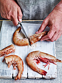 Preparing prawns: removing heads