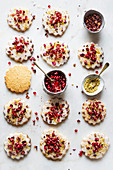 Cookies with icing, pomegranate seeds and rose petals
