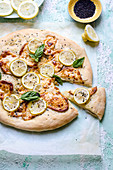 Pizza mit Scamorza, Zitronenscheiben und schwarzem Sesam