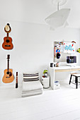 Gitarren an der Wand, Bodenkissen und Schreibtisch im Jugendzimmer