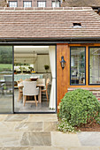 View from terrace through open glass sliding doors into open-plan kitchen
