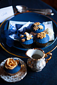 Perfectly decorated cupcakes with blue and gold toppings