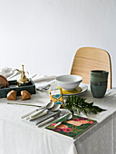 Gardening tools, crockery and cutlery on dining table with tablecloth