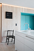 Moderne, minimalistische Küche mit hellem Holz und blauer Sitznische