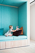 Girl playing in seating niche upholstered in pale blue