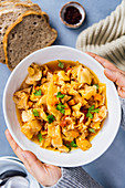 Hands holding a large bowl of vegan cabbage soup photogrpahed with a comforting feeling