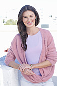 A young woman with long hair wearing a purple t-shirt and a wrap-around jumper